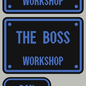 Op de afbeelding: Vier rechthoekige zwarte borden met blauwe randen en blauwe tekst. Twee grote borden bevatten de tekst DAN WORKSHOP en THE BOSS WORKSHOP. Twee kleinere borden bevatten de namen DAN en ALEXANDER, elk met een rond gat aan de linkerkant.