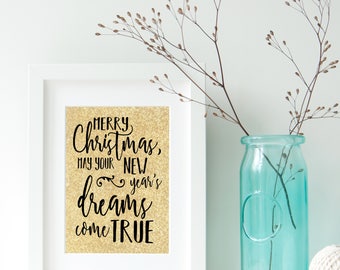 May include: A white framed print with a gold glitter background and black text that reads "Merry Christmas, May your New Year's dreams come true".
