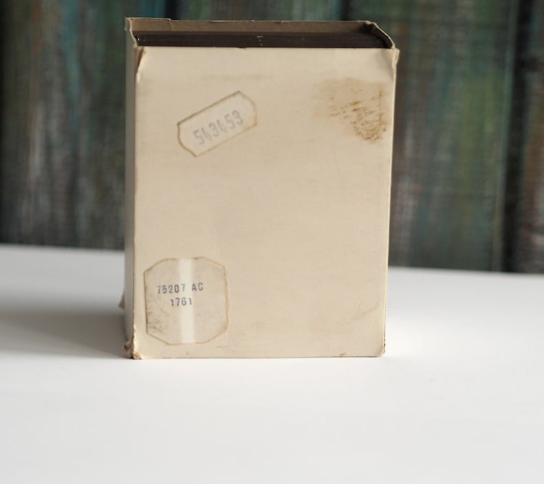 May include: A white cardboard box with brown tape and two labels. The top label says "543653" and the bottom label says "75207 AC 1761".