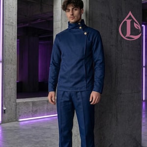 May include: A dark blue high-collar jacket with an asymmetrical front closure featuring two gold-toned buttons, paired with matching dark blue trousers. The jacket has long sleeves and a structured fit, creating a uniform-like appearance.
