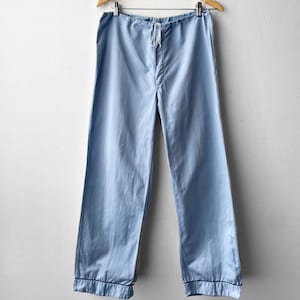 May include: Light blue pyjama trousers with a drawstring waist and black trim around the cuffs.