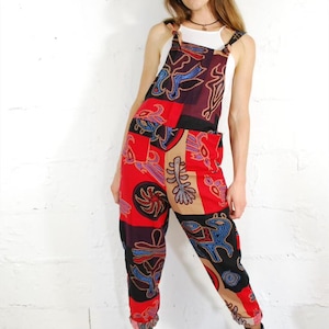 Puede incluir: Una mujer con un mono estampado en rojo, negro y azul, con un top blanco y botas negras.