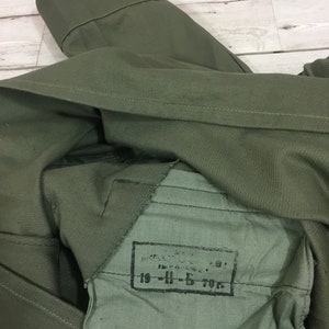 May include: A green military jacket with a label that reads "19-H-5 70г."
