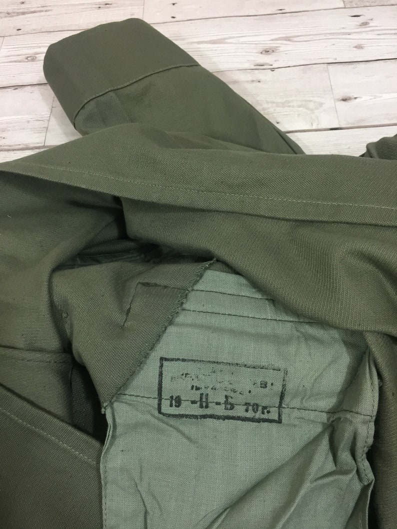 May include: A green military jacket with a label that reads "19-H-5 70г."