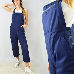 May include: A pair of dark blue denim overalls with a zipper closure and button accents. The overalls have a relaxed fit and are made of a soft, comfortable fabric.