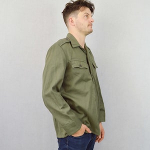 May include: A green long-sleeved shirt with a button-up collar and a pocket on the chest. The shirt has a relaxed fit and is made of a soft, comfortable fabric.