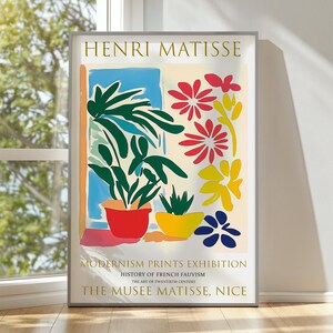 May include: A framed Henri Matisse exhibition poster featuring a colorful illustration of potted plants and flowers. The text reads HENRI MATISSE, MODERNISM PRINTS EXHIBITION, HISTORY OF FRENCH FAUVISM, THE ART OF TWENTIETH CENTURY, THE MUSEE MATISSE, NICE.