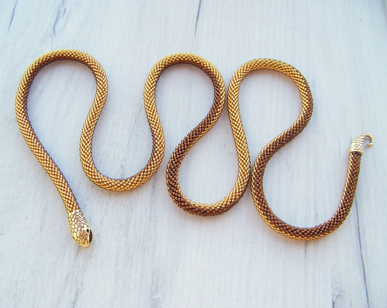 May include: A gold and brown beaded snake necklace with a gold snake head charm.