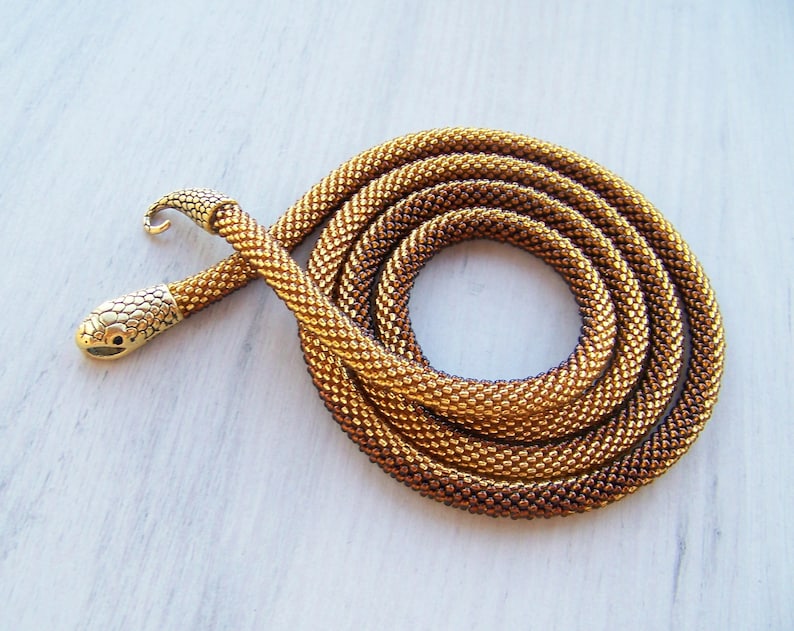 May include: A gold and brown beaded snake necklace with a snake head clasp.