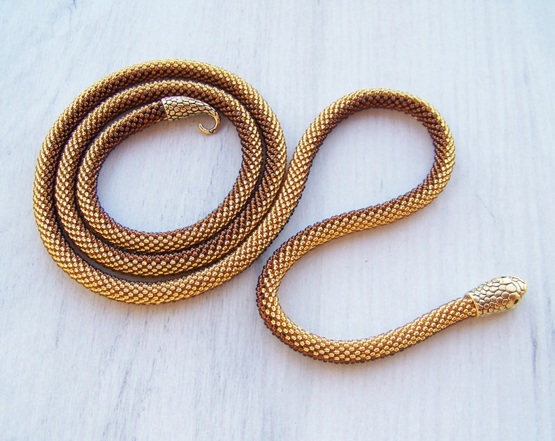 May include: A gold and brown beaded snake necklace with a gold snake head charm.