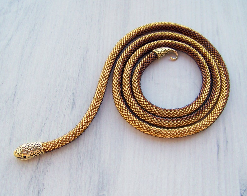 May include: A gold and brown beaded snake necklace with a gold snake head clasp.
