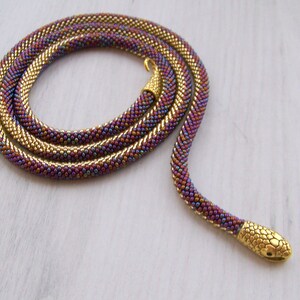 May include: A gold and purple beaded snake necklace with a gold snake head charm.