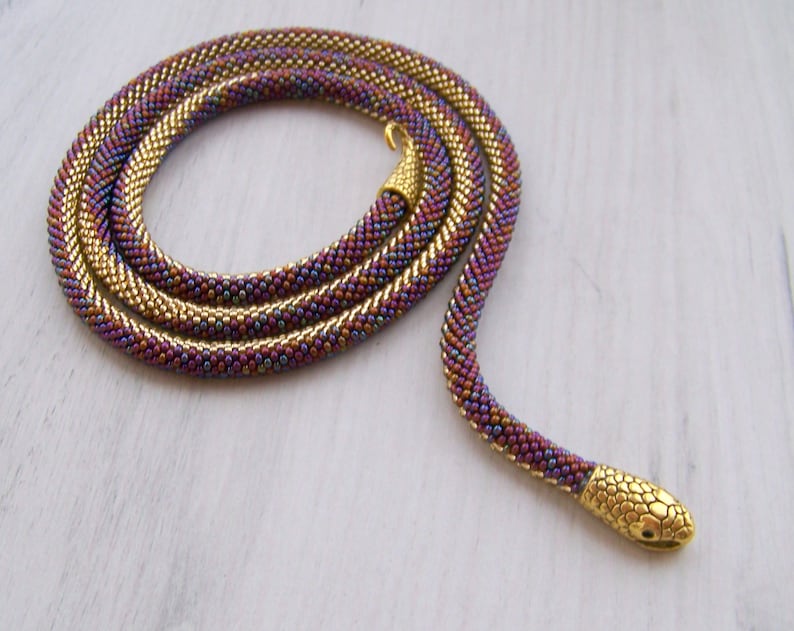 May include: A gold and purple beaded snake necklace with a gold snake head charm.