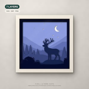 Puede incluir: Una obra de arte de papel recortado de 7 capas en un marco cuadrado con la silueta azul oscuro de un ciervo en un paisaje forestal bajo una luna creciente y estrellas. El texto incluye 7 LAYERS, SVG, DXF, PNG y FJELL & FERN CUTS.