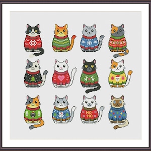 Op de afbeelding: Een ingelijste kruissteek met twaalf cartoonkatten, elk met een andere patroon trui. De katten hebben verschillende vachtkleuren, en de truien hebben vakantie-thema ontwerpen.