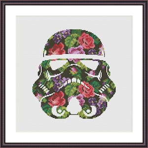 May include: A cross-stitch pattern of a Star Wars Stormtrooper helmet, with a floral design in shades of pink, purple, and green.