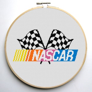 May include: Cross-stitch pattern of the NASCAR logo. The logo features a checkered flag, the word "NASCAR" in colorful letters, and a yellow and orange striped background.