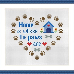 Może przedstawiać: Wzór haftu krzyżykowego w kształcie serca wykonany z odcisków łap. Tekst brzmi "Home is where the paws are" z budą dla psa i kością w środku.
