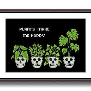 May include: A framed cross-stitch design with the text "Plants make me happy" and four potted plants with skull-shaped pots. The plants are green and the pots are white.
