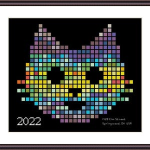 Może przedstawiać: Oprawiony portret kota w stylu pixel art w różnych kolorach na czarnym tle. Grafika zawiera rok "2022" oraz adres "1428 Elm Street, Springwood, OH USA" w białym tekście.