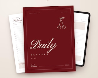 May include: A 2027 daily planner with a deep red cover featuring a white cherry line drawing and the text Daily Planner 2027. The planner is displayed with two open pages showing daily scheduling layouts and a list of features at the bottom.