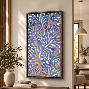 May include: A rectangular wall art piece in a dark wood frame featuring a vibrant blue coral-like pattern painted over a warm orange and yellow watercolor background. The artwork displays intricate, branching organic shapes in deep blue.