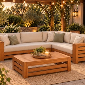 May include: An L-shaped outdoor sectional sofa and a matching rectangular coffee table made of light brown wood with horizontal slats. The sofa features thick beige cushions and several decorative pillows in beige and olive green.
