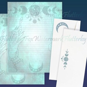 May include: Three sheets of stationery paper with a blue and white moon and star design. The paper has a light blue background with a subtle watercolor effect. The top sheet has a hand with a snake wrapped around it. The bottom sheet has a moon and star design with a crescent moon and a star in the center. The middle sheet has a moon and star design with a crescent moon and a star in the center. The paper is blank and ready to be written on.