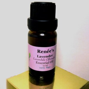 May include: A small brown glass bottle with a black cap, labeled "Renée's Lavender Lavandula Officinalis Essential Oil 10 ml 100% Pure" on a pink label.