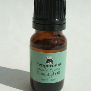 May include: A small brown glass bottle with a black lid, labeled "Peppermint Mentha Piperita Essential Oil 10 ml 100% Pure".
