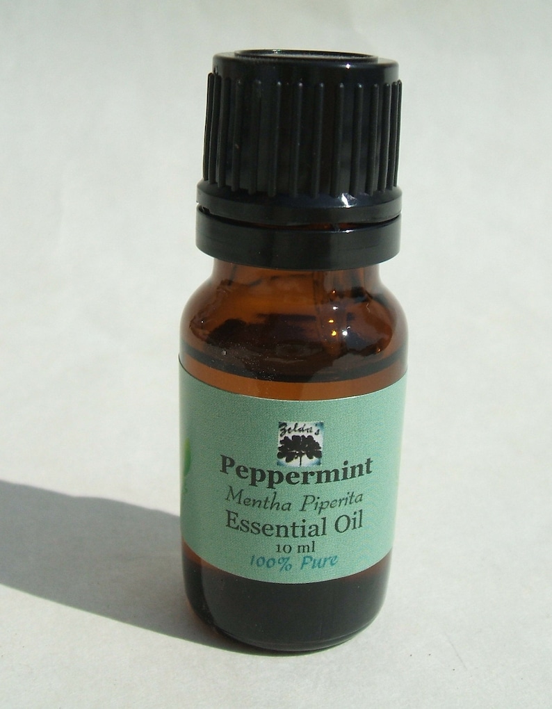May include: A small brown glass bottle with a black lid, labeled "Peppermint Mentha Piperita Essential Oil 10 ml 100% Pure".