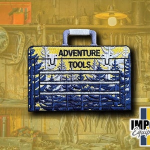 May include: A yellow and blue embroidered patch shaped like a toolbox with the text "Adventure Tools" on the front. The patch is surrounded by a wooden background with tools and other items.