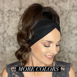 May include: A black twisted headband is worn by a person with dark brown hair. The text "MORE COLORS" is displayed in a black rectangle across the bottom of the image. The person is wearing a gray lace top.