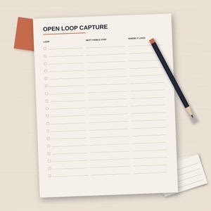 May include: A cream-colored Open Loop Capture task sheet with a dark blue pencil resting on top. The sheet features three columns labeled Loop, Next Visible Step, and Where It Lives, with rows of checkboxes and horizontal lines for writing.