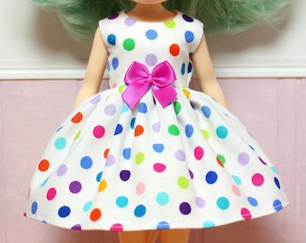 May include: A white dress with a colorful polka dot pattern and a pink bow at the waist.