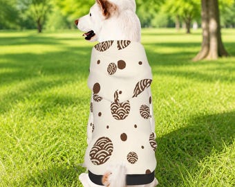 Puede incluir: Una sudadera con capucha para perro de color crema con un patrón repetitivo de formas circulares marrones y diseños de ondas. La prenda incluye una capucha y un dobladillo negro sólido en la parte inferior, ajustada al torso.