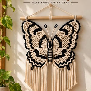May include: A macramé butterfly wall hanging pattern featuring black and cream cord knots on a wooden dowel. The text reads Macramé Butterfly WALL HANGING PATTERN. The butterfly has intricate knotted wings and long fringe tassels hanging from the bottom.