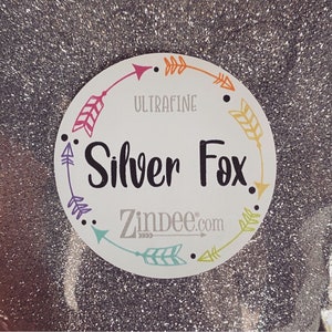 May include: A white circle with a colorful arrow border. The text "Ultrafine Silver Fox" is in black lettering. The text "ZinDee.com" is in gray lettering.