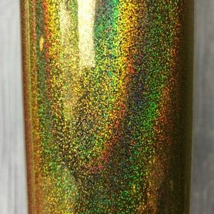 May include: A close-up of a gold iridescent glitter vinyl sheet. The glitter is fine and creates a shimmering effect.