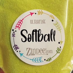 May include: A close-up of a bag of yellow glitter labeled "Ultrafine Softball" with a white circle around the text and a border of colorful arrows.