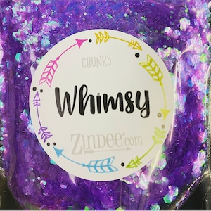 May include: A close-up of a bag of purple and iridescent chunky glitter. The bag has a white label with the words "Whimsy" and "Zindee.com" printed on it.