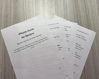 May include: A stack of white paper sheets featuring an iPhone Guide for Seniors. The text includes instructions for Apple iPhones, FaceTime, and accessibility settings. The pages are numbered at the bottom, with clear black printed text.