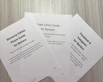 May include: Three white informational guides for seniors titled Samsung Galaxy Phone Guide for Seniors, Scam Safety Guide for Seniors, and Facebook & Instagram for Seniors, featuring black printed text on standard letter-sized paper sheets.