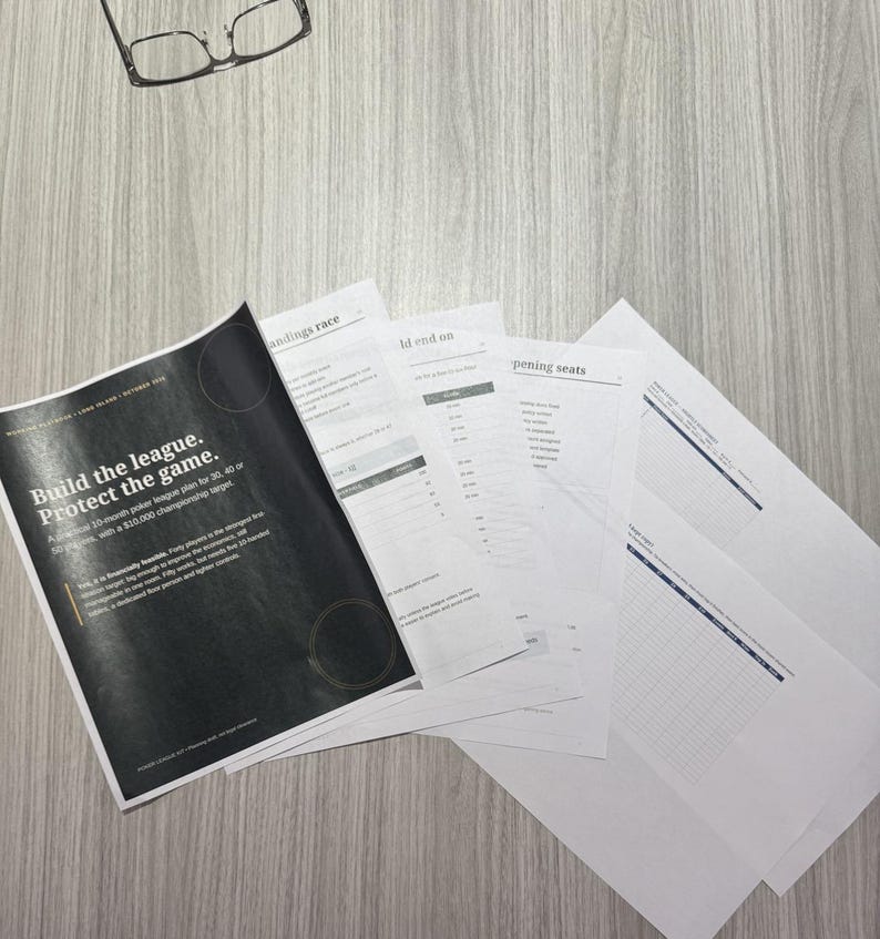 May include: A stack of printed documents featuring a black cover page with the white text Build the league. Protect the game. and additional pages with tables and lists, accompanied by a pair of black-rimmed eyeglasses resting nearby.