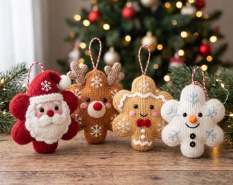 May include: Four knitted holiday ornaments shaped like stars, featuring a Santa Claus, a reindeer, a gingerbread person, and a snowman. Each ornament has a red and white striped hanging loop and is decorated with embroidered snowflake details.