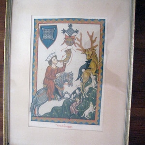 May include: A framed medieval-style illustration featuring a person on a horse blowing a horn, a stag, and hunting dogs. The scene includes a blue shield, a crest, and the text Von Súnegge. The artwork is bordered by a blue and orange diamond pattern.