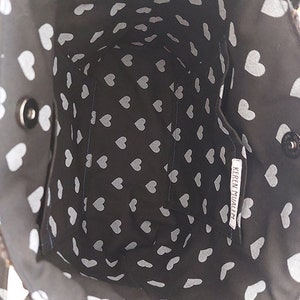 May include: Black tote bag with a white heart pattern. The bag has a small inside pocket with the text "KEREN MIJALE" printed on it.