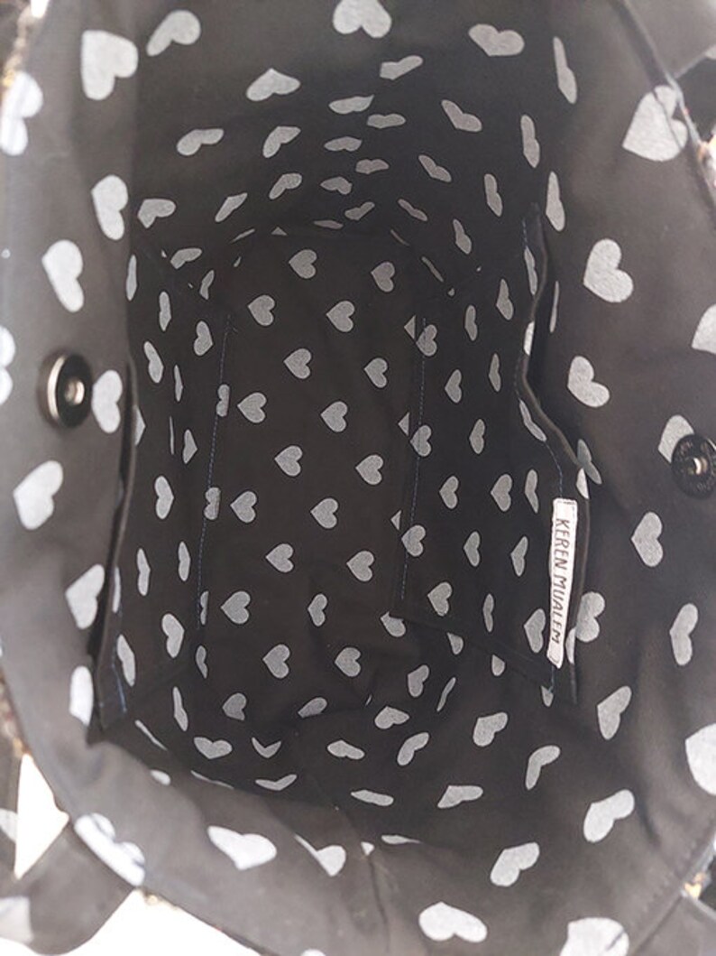 May include: Black tote bag with a white heart pattern. The bag has a small inside pocket with the text "KEREN MIJALE" printed on it.