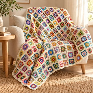 May include: A crochet blanket featuring a repeating granny square pattern in a vibrant array of colors including red, blue, yellow, green, and purple, all bordered by a cream-colored yarn that connects each individual square together.