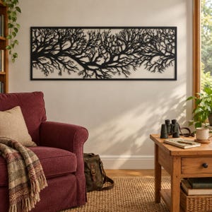 Puede incluir: Una pieza de arte mural rectangular de metal negro que presenta una silueta detallada e intrincada de ramas de árboles y raíces extendidas. El diseño está encerrado en un marco negro fino, creando una pantalla horizontal ancha.